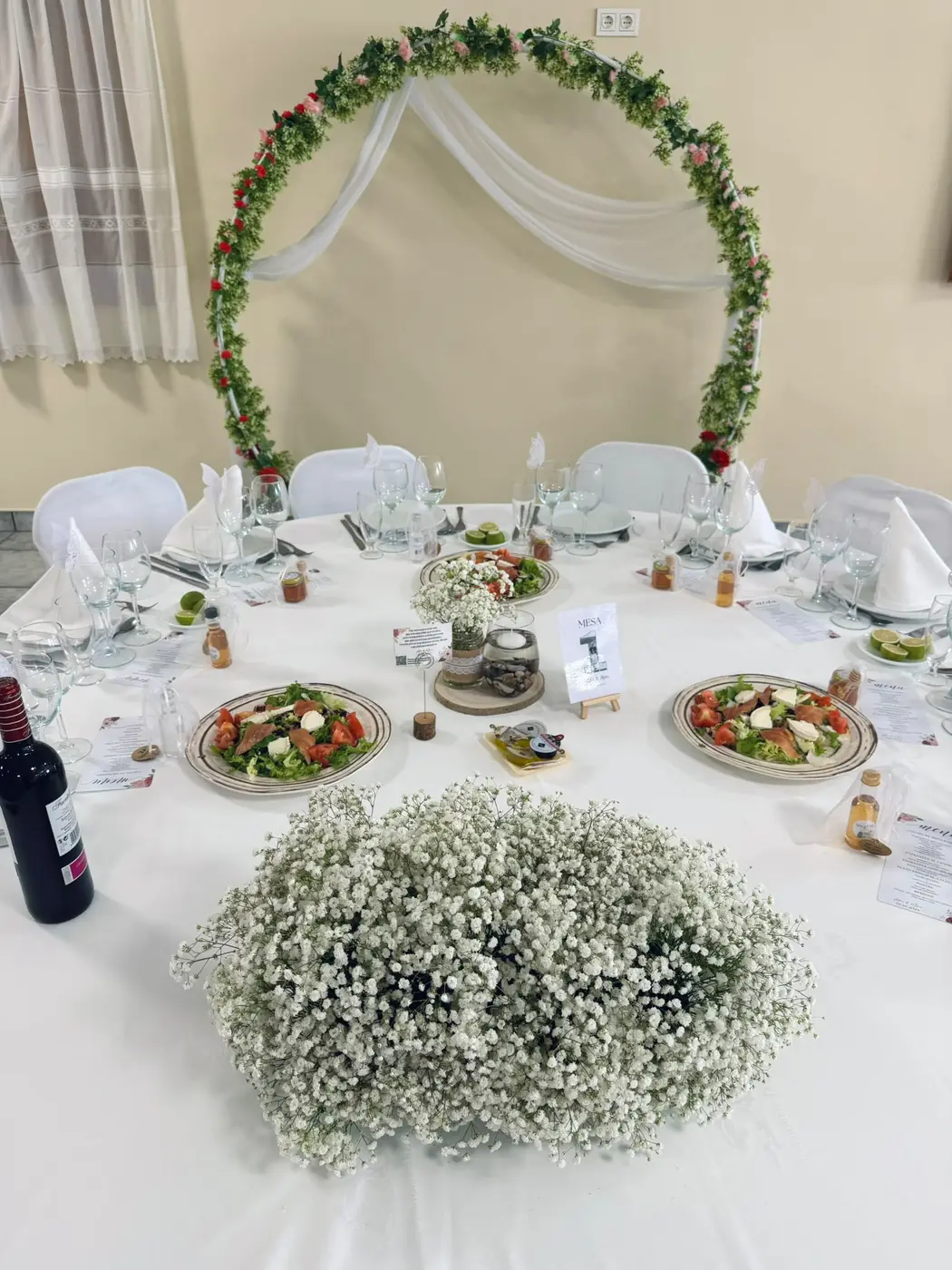 Mesa con flores y arco de la ceremonia